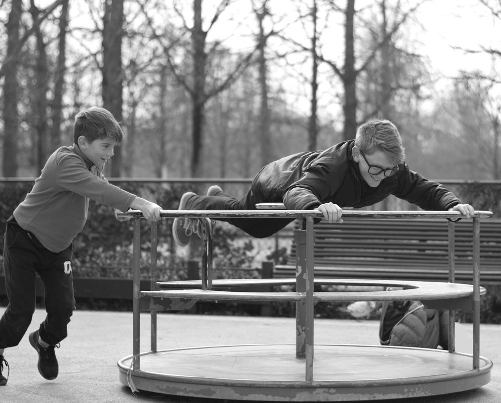 Photo of brothers playing on the merry-go-round at Tuileries playground in Paris.