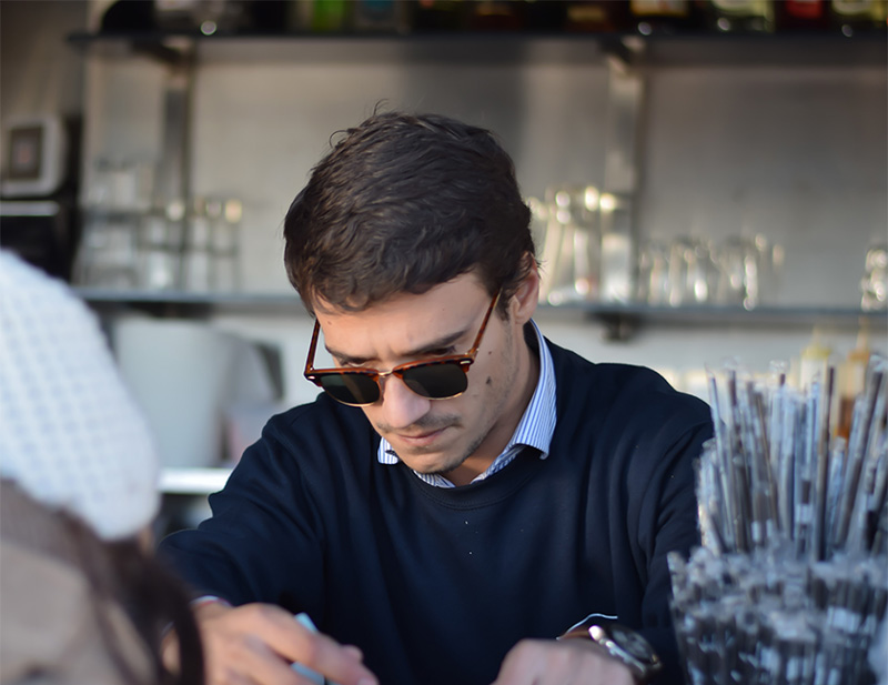 a man pouring an espresso at a kiosk in Lisbon Portugal