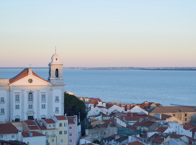 Late afternoon sun hitting the pretty pastel buildings of Lisbon's Alfama neighborhood