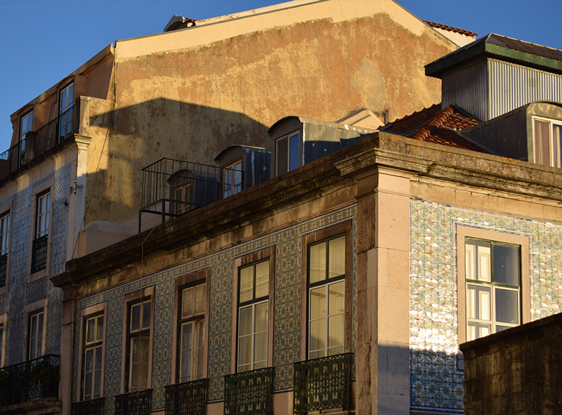 Late afternoon sun is hitting the ceramic tiles of a Lisbon building