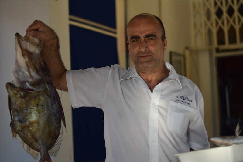 image of a waiter holding a fresh caught fish in a restaurant in Cabo de Gata Natural Park in Spain