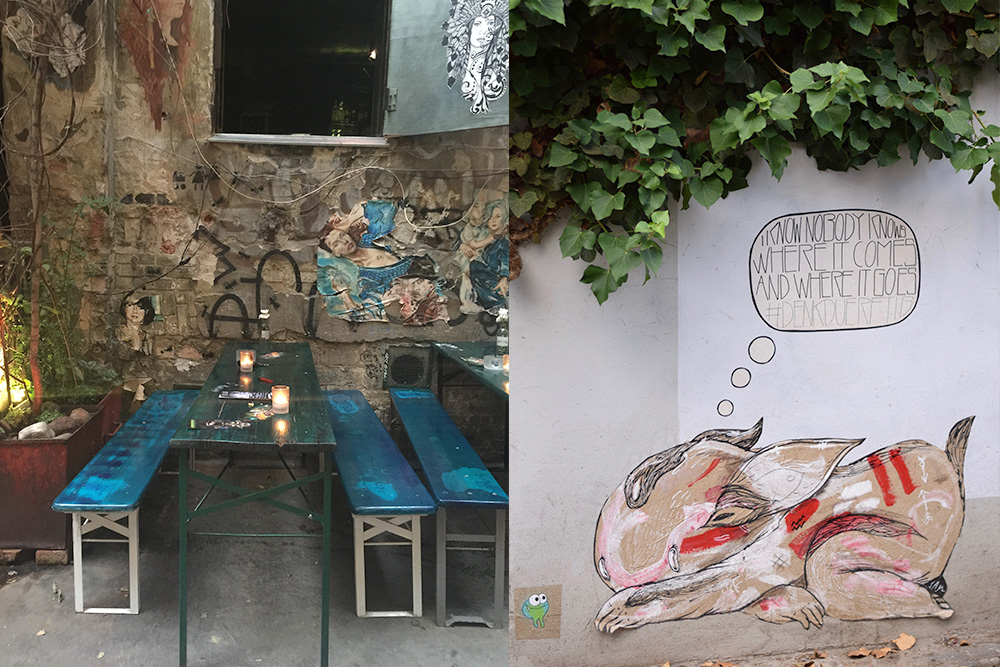 A photo of a colorful cafe table near a wall thick with graffiti in Berlin, Germany.