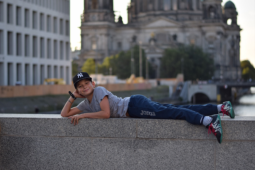 Photo of a boy (a tourist) posing on the River Spree in Berlin, Germany.