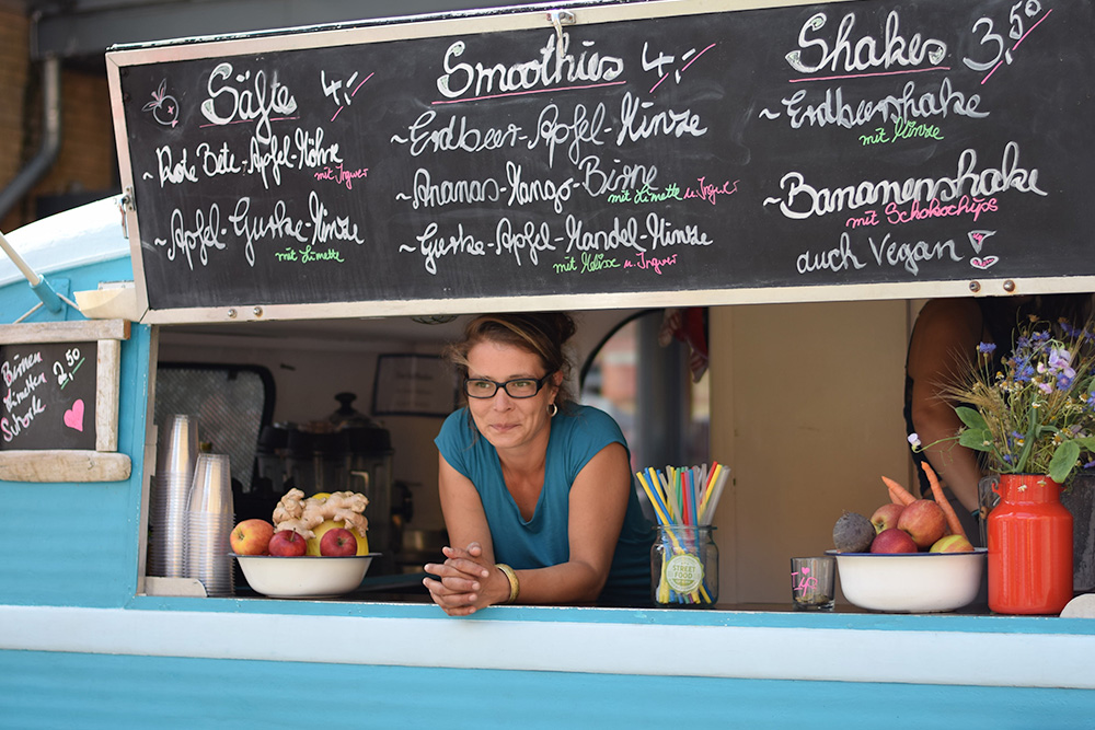 Photo of a woman serving food from her food truck in Berlin, Germany.