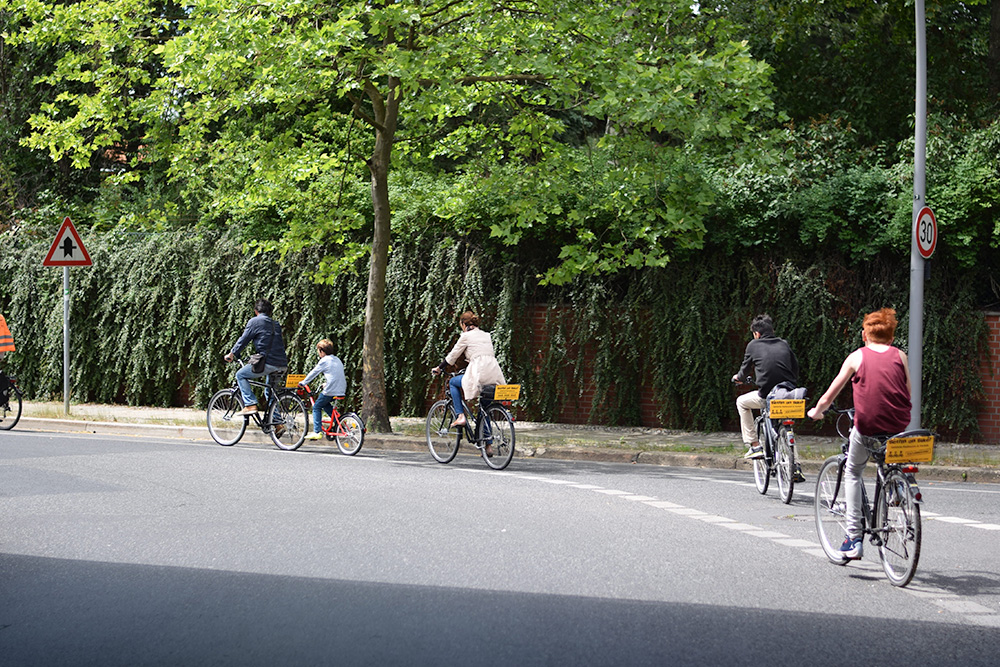 A photo of two families riding bicycles on the streets of Berlin, Germany while on a Berlin on Bike tour of the Berlin Wall.