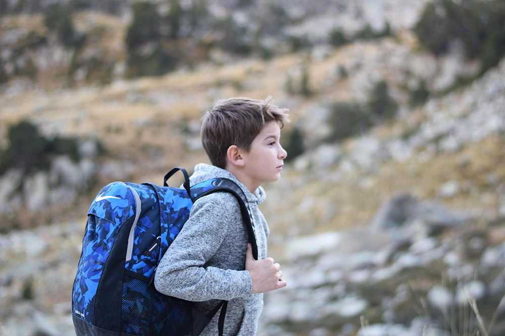 A boy with his backpack on preparing to hike up a hill in the Spanish Pyrenees.