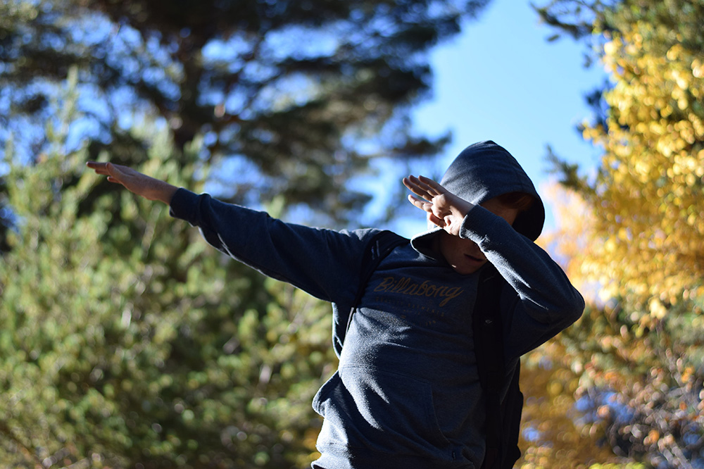 Photo of a teenage boy "dabbing" after a hike through the Pyrenees of Spain.