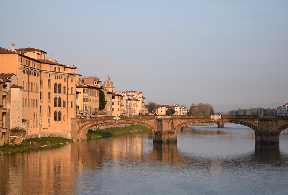 Photo of a river running through Florence, Italy at sunrise