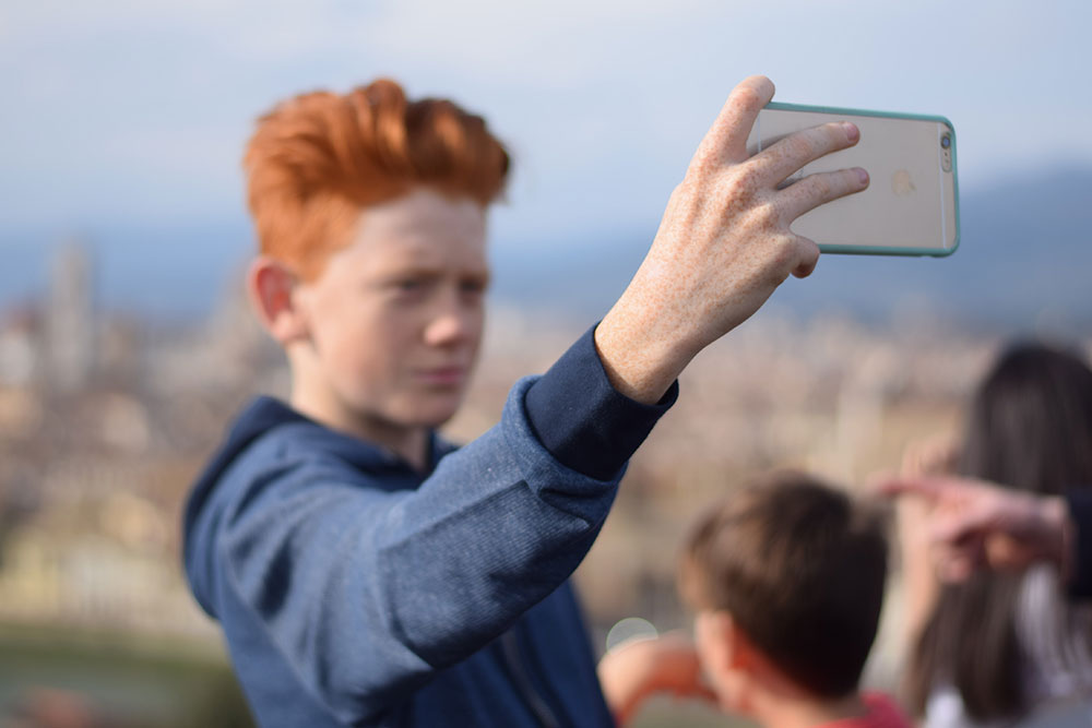 Photo of a boy taking a 'selfie' overlooking the cit of Florence, Italy