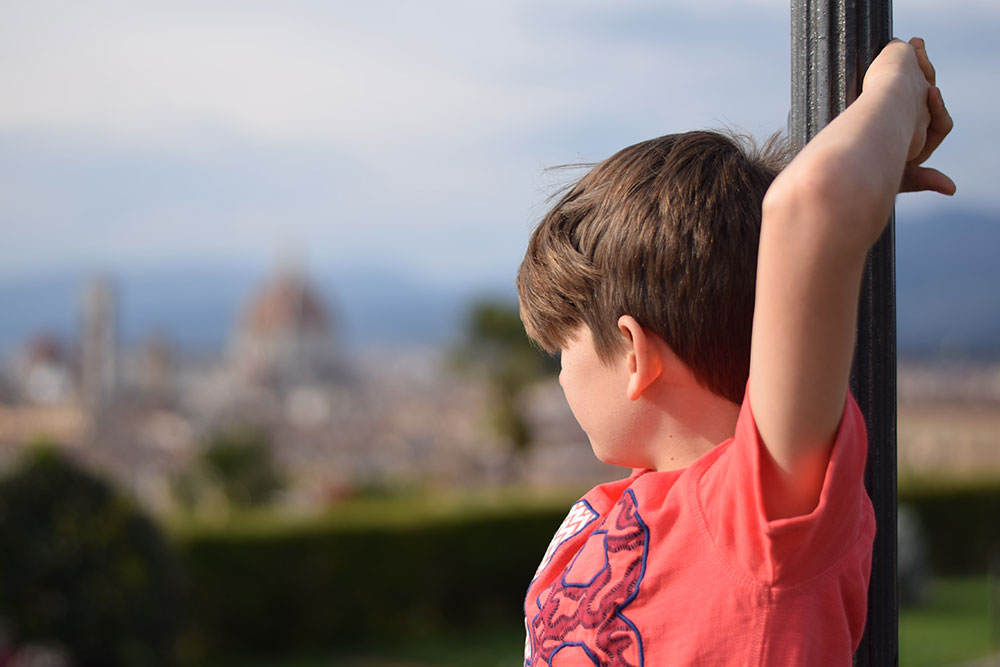 Photo of a boy looking out across the city of Florence, Italy