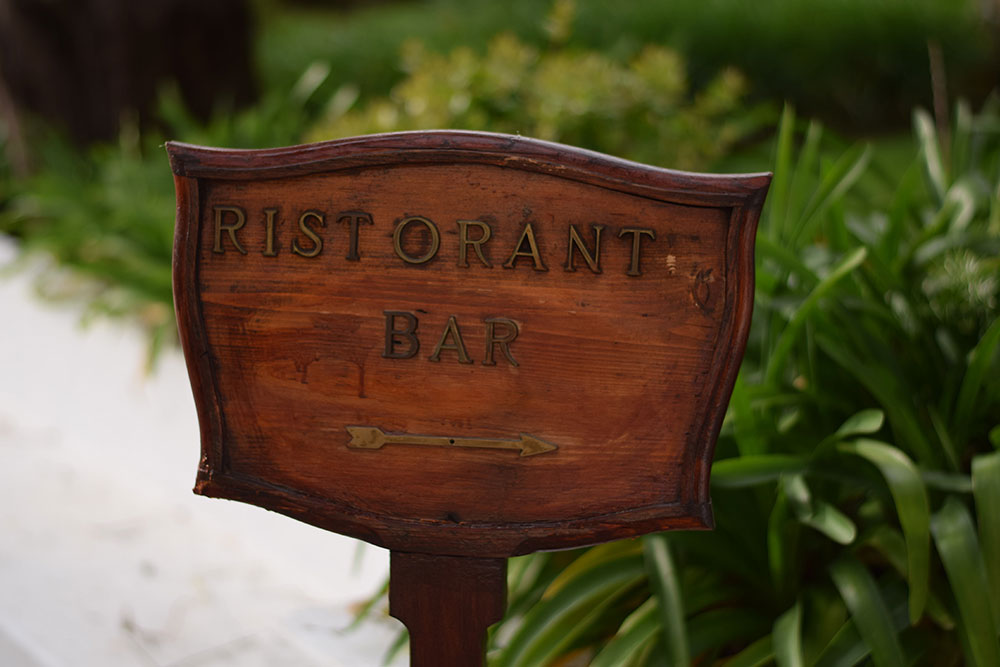 Photo of a sign that says "Risorante Bar" with an arrow pointing to the right in Ravello, Italy.