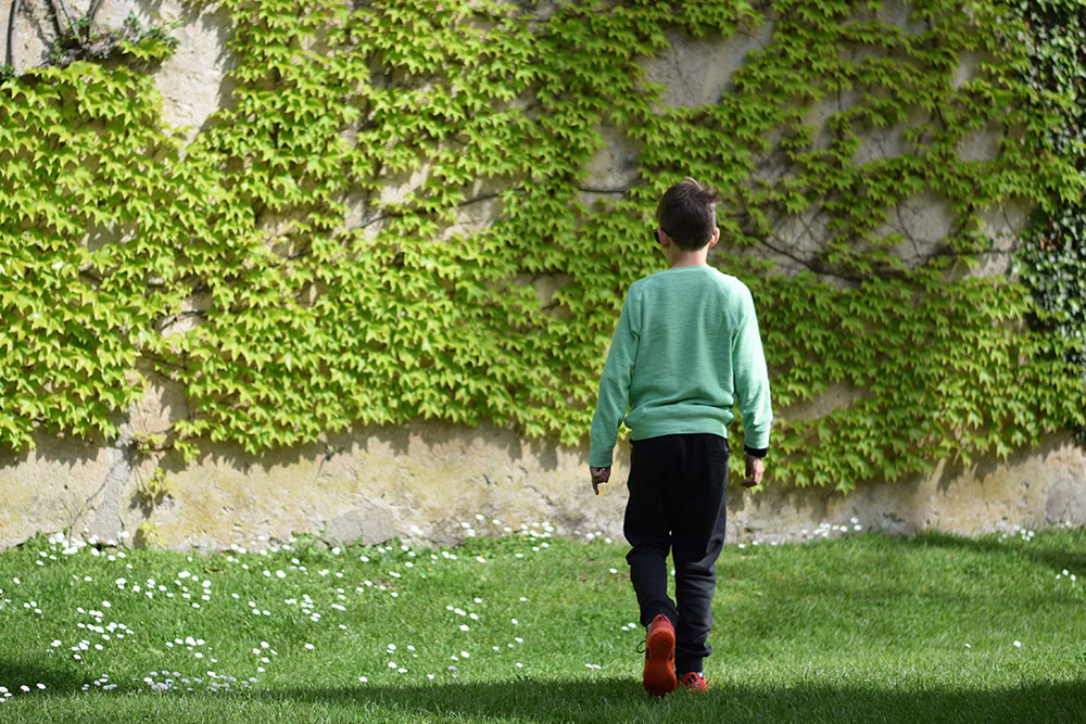 Photo of a boy walking in a garden at Villa Cimbrone in Ravello, Italy.