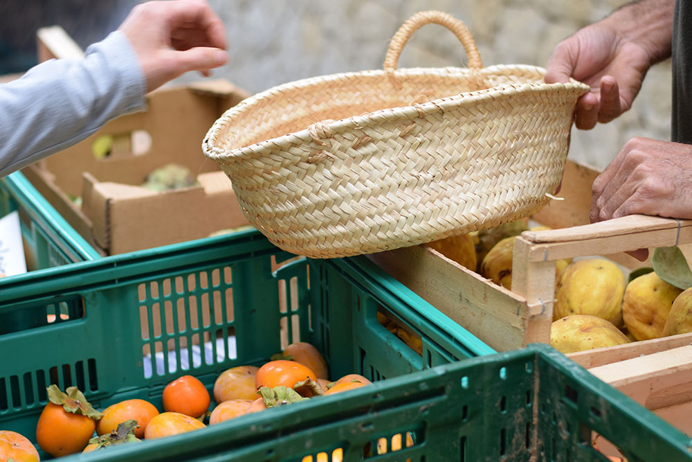 A photo of a farmer's market stall selling persimmons and a basket.