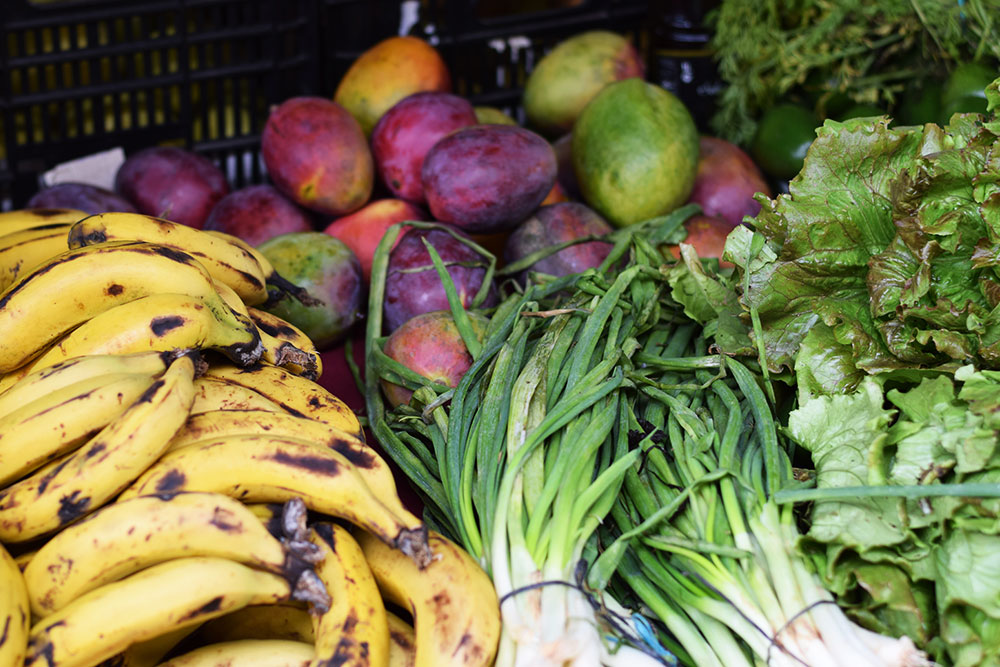 Photograph of bananas, spring onions, mangos and lettuce at the Santa Maria market in Mallorca, Spain.