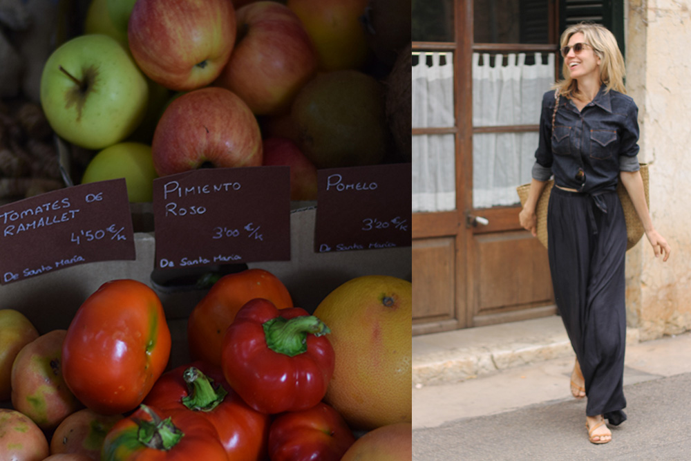 Photograph of fruits and vegetables for sale and a woman walking at the Santa Maria market in Mallorca, Spain.