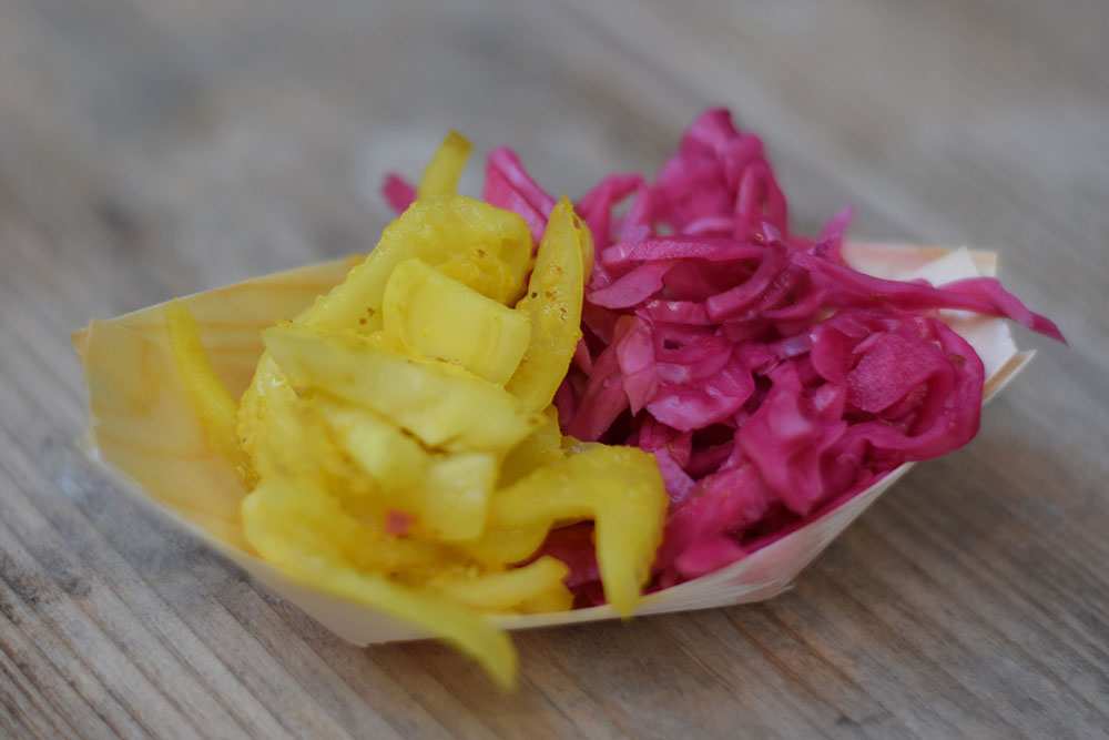 A colorful bowl of bright yellow and pink fermented cabbage from a restaurant called Fento in Foodhallen, in Amsterdam. 