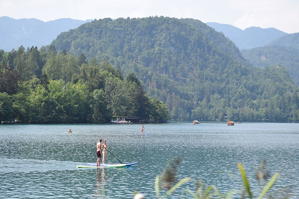 Photo of Lake Bled, Slovenia showing people on paddle boards.