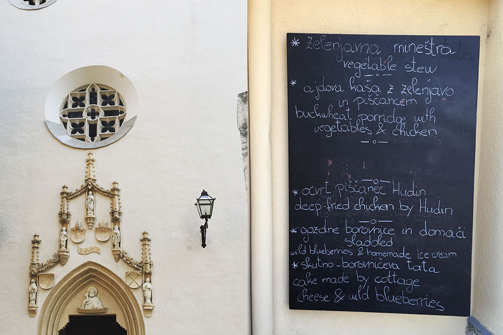 Photo of a church facade and a restaurant menu in Radovljica, Slovenia.