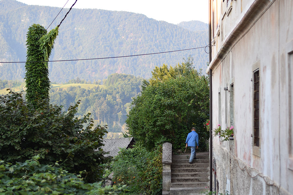 Photo of an old man walking up the steps to his house in Radovljica, Slovenia.