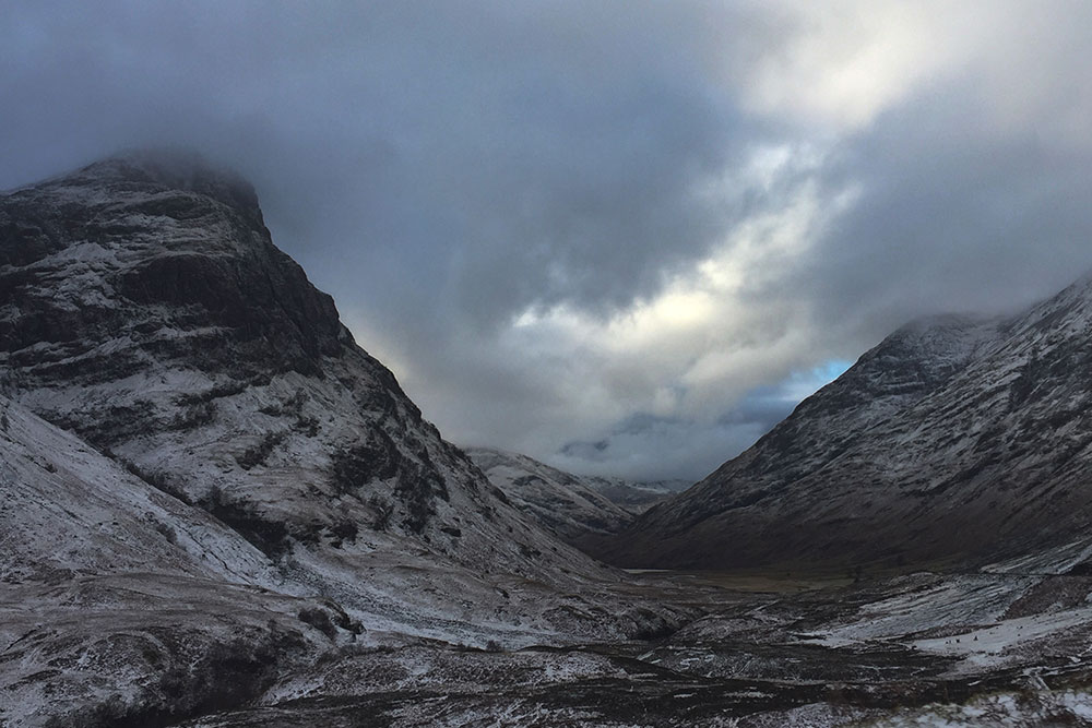 Photo of the dark snowy mountains of Glencoe, in Scotland.