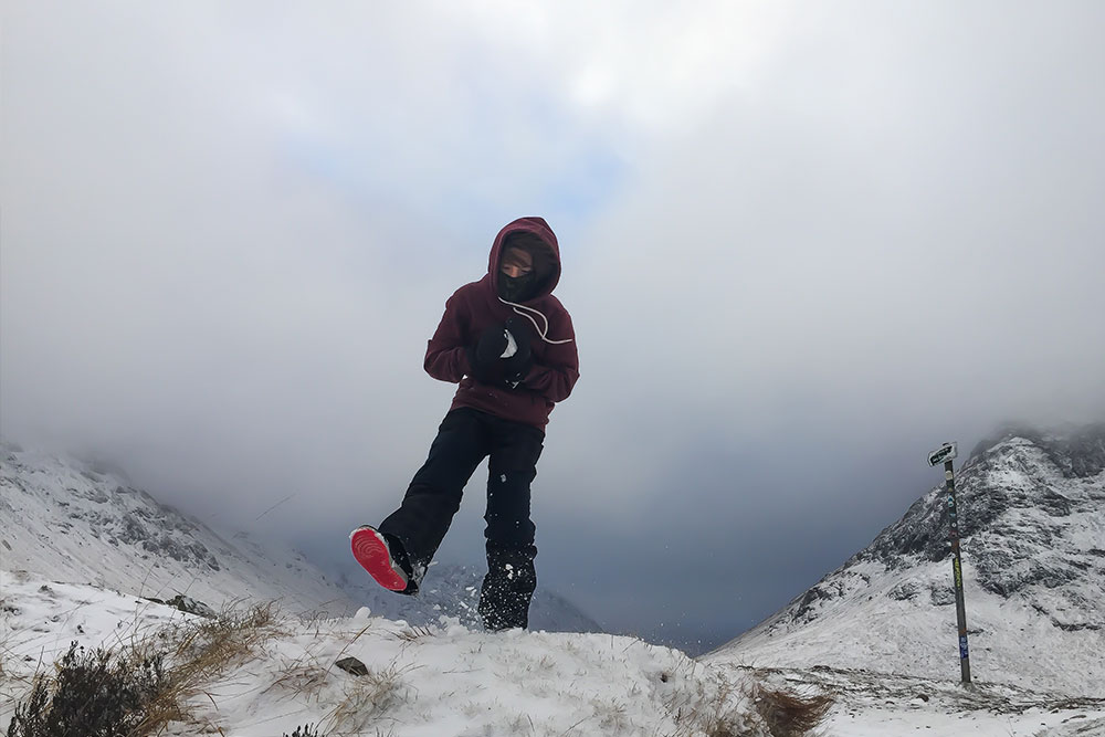 A boy preparing to throw a snowball in a snowy winter scene.