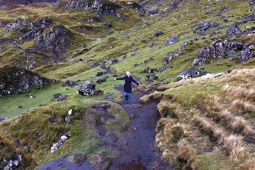 A women walking along a trail in The Quaraing on the Isle of Skye, in Scotland, in winter.